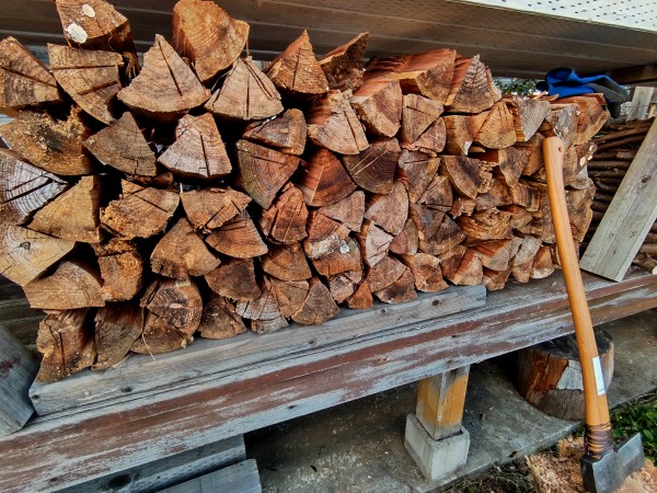 杉の玉を斧で割ってデッキに積んだ薪